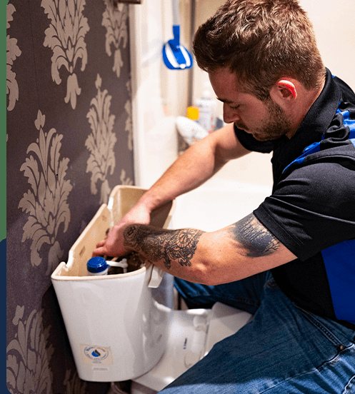 Acts of Service Plumbing technician repairing a toilet tank