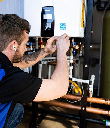 Acts of Service Plumbing technician servicing a tankless water heater